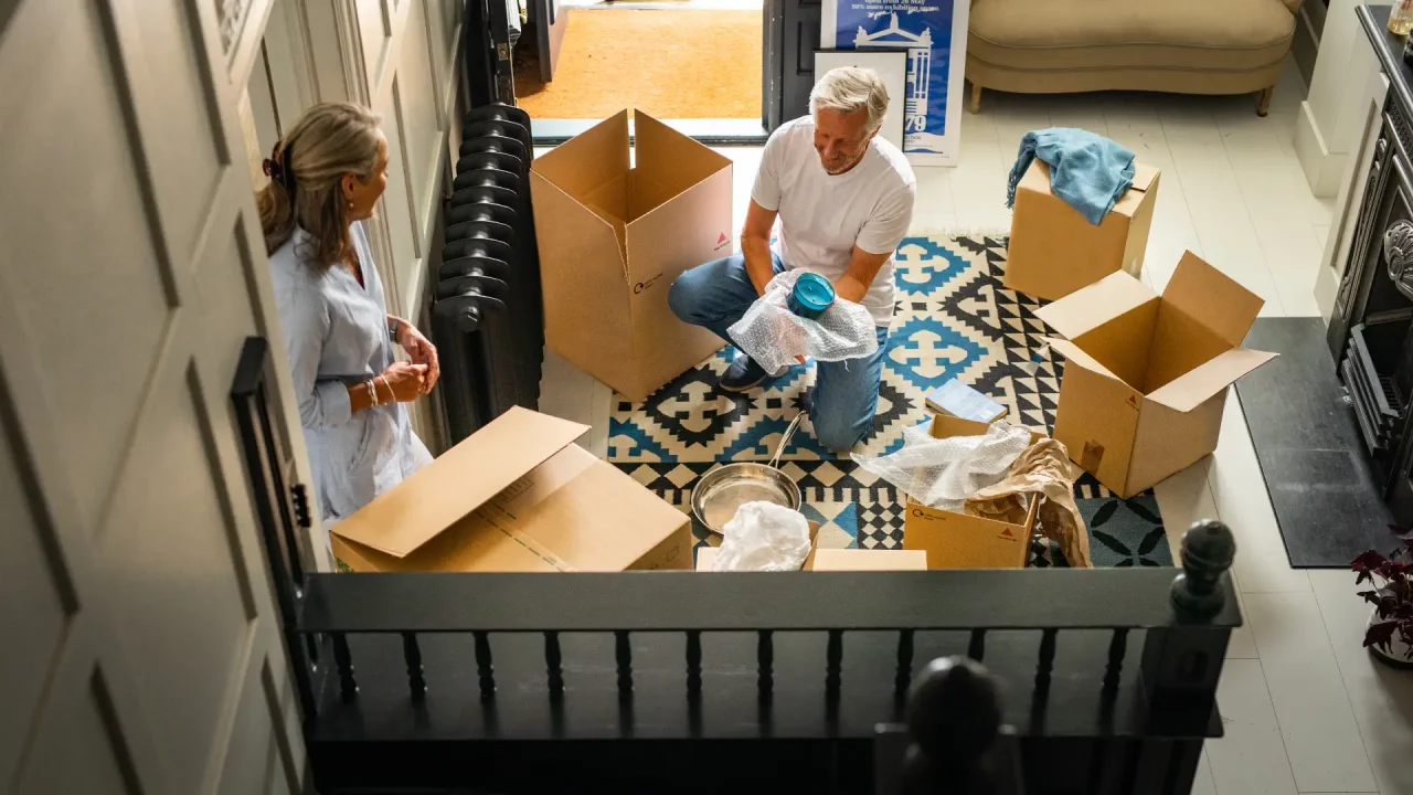 man and women packing in hallway on a patterned rug